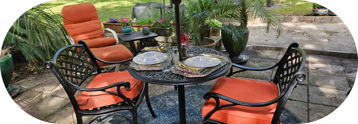 A table with two plates and a umbrella.
